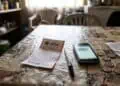 image of a Daily Lotto ticket on a table with South African rand coins and a smartphone on a table.