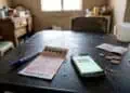 image of a powerball ticket on a table with South African rand coins and a smartphone on a table.